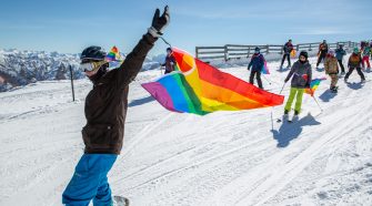 People Skiing through snow with pride flags
